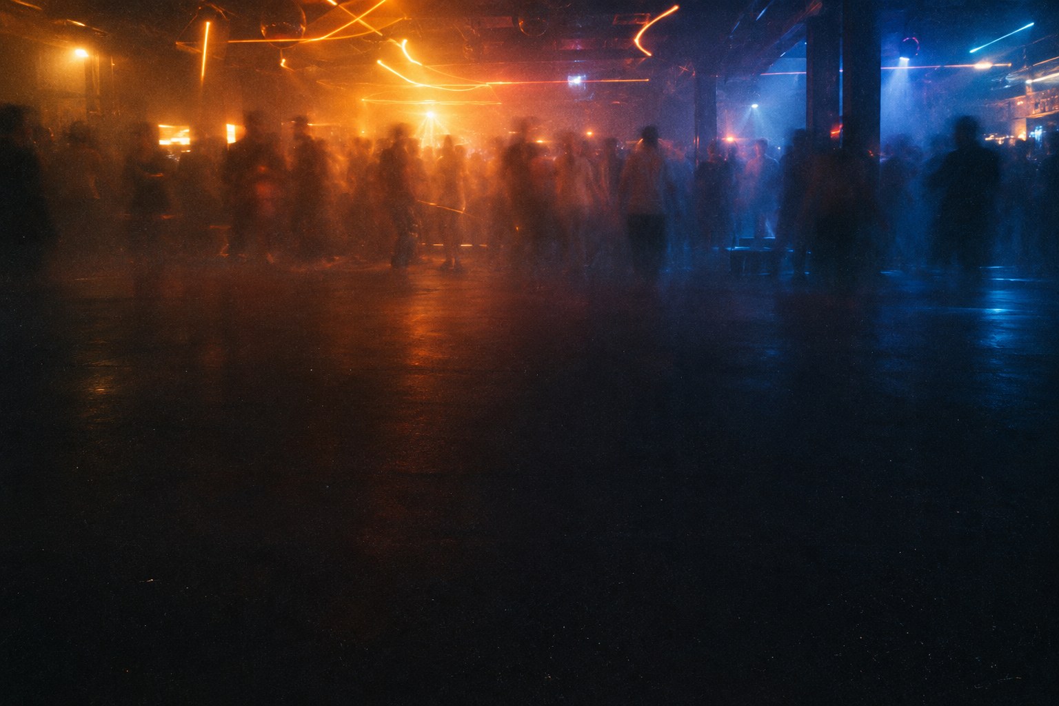 Moving silhouettes on a dance floor, between amber light and blue shadows